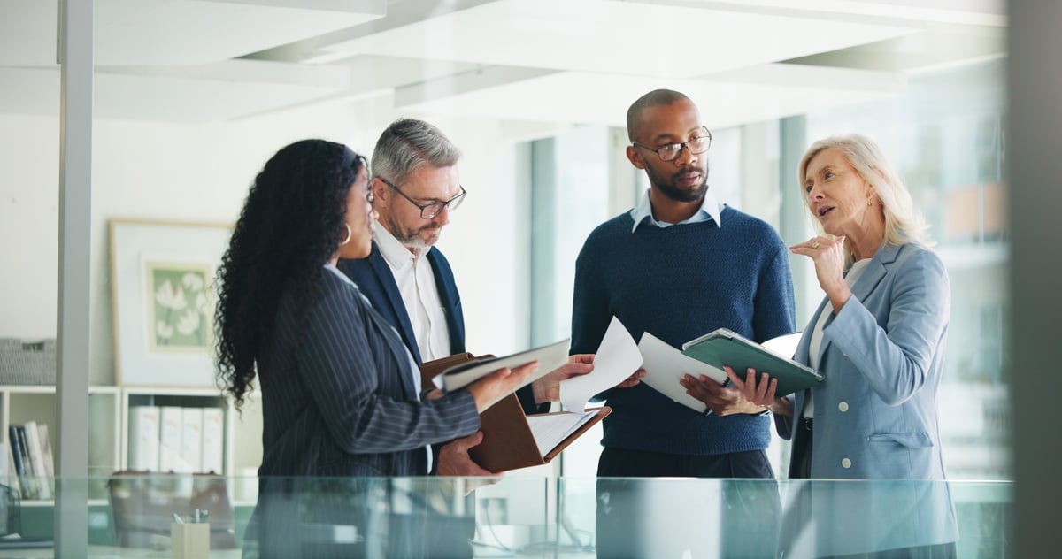 Risk and compliance professionals reviewing financial policy and regulatory documents in a strategy meeting